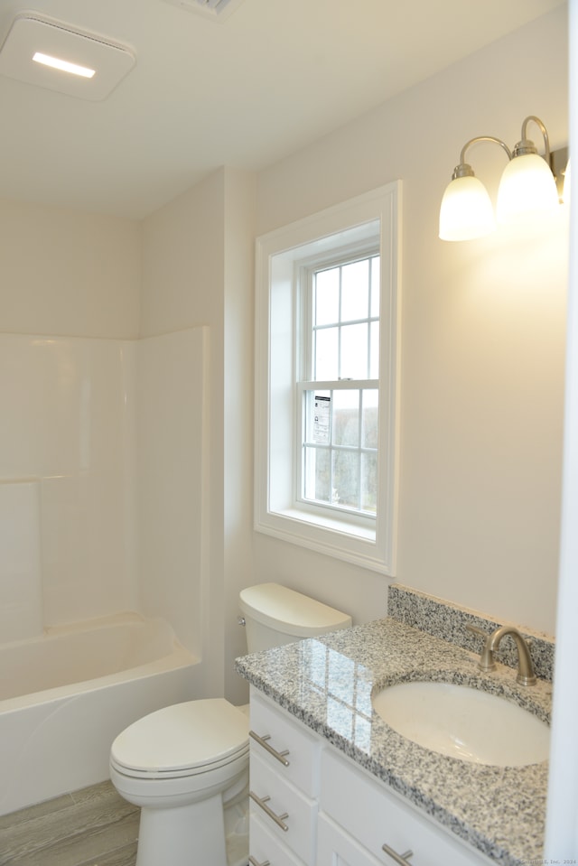 full bathroom featuring hardwood / wood-style flooring, vanity, shower / bathtub combination, and toilet