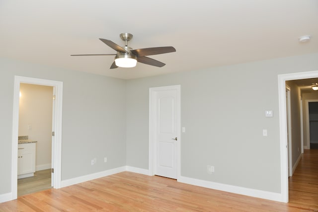 unfurnished bedroom featuring connected bathroom, light hardwood / wood-style flooring, and ceiling fan