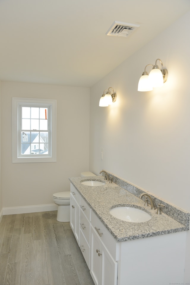 bathroom with hardwood / wood-style floors, vanity, and toilet