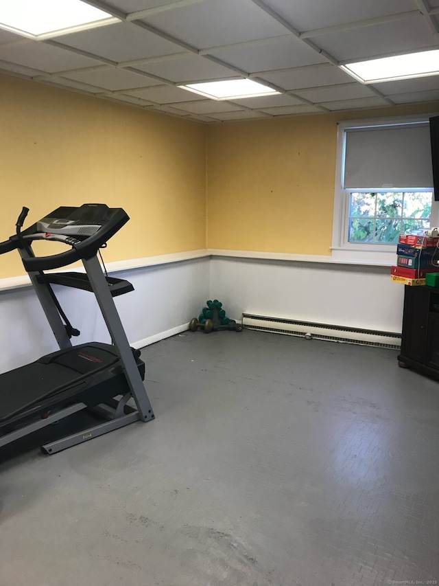 workout area with a drop ceiling and a baseboard radiator