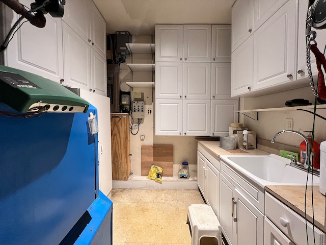 clothes washing area featuring electric panel and sink