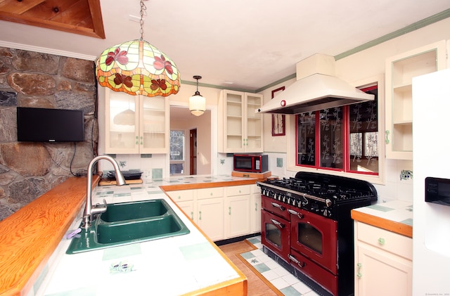 kitchen with pendant lighting, black appliances, crown molding, sink, and island range hood