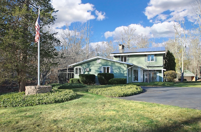 view of side of property with solar panels and a yard