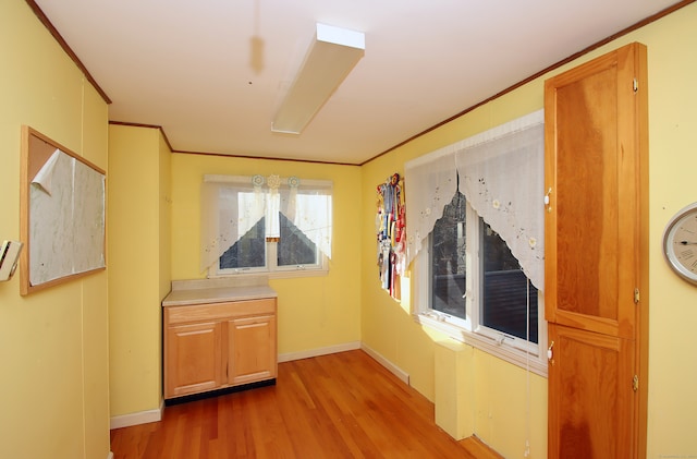 hall featuring light hardwood / wood-style floors and ornamental molding