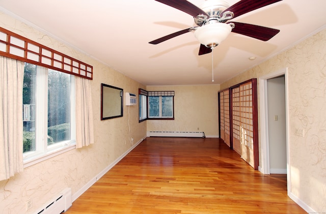 spare room with hardwood / wood-style flooring, ceiling fan, ornamental molding, and a baseboard radiator