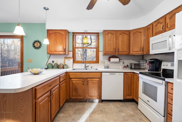 kitchen with white appliances, sink, ceiling fan, decorative light fixtures, and kitchen peninsula