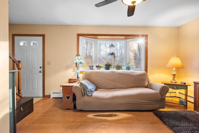 sitting room featuring ceiling fan, light wood-type flooring, and baseboard heating