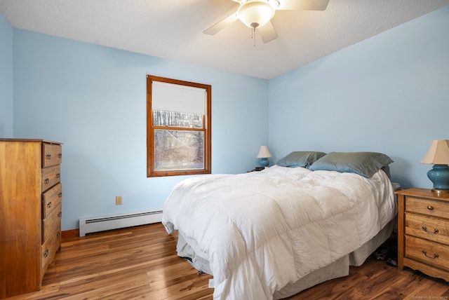 bedroom with ceiling fan, dark hardwood / wood-style flooring, a textured ceiling, and a baseboard radiator