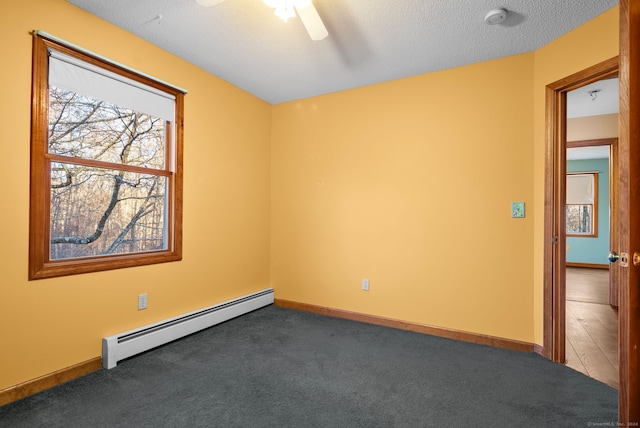 unfurnished room with dark colored carpet, a textured ceiling, ceiling fan, and a baseboard heating unit