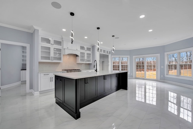 kitchen with decorative light fixtures, decorative backsplash, ornamental molding, a large island, and white cabinetry