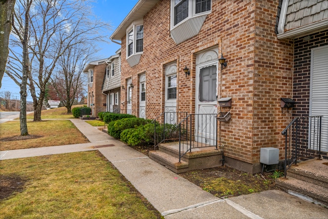 view of exterior entry featuring a yard