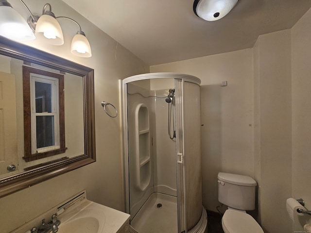 bathroom with vanity, toilet, and a shower with shower door