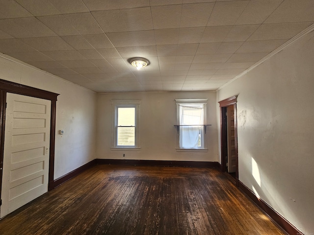 spare room featuring crown molding and dark hardwood / wood-style flooring