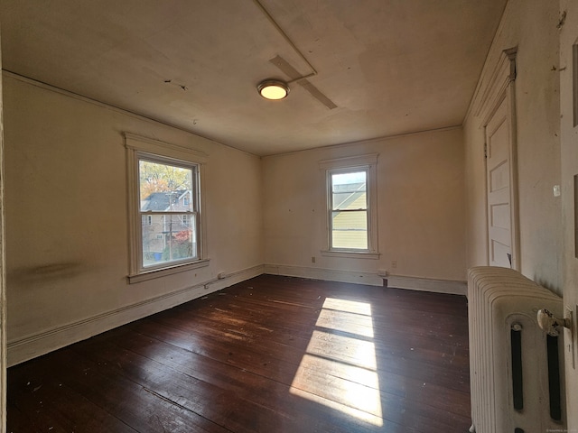 unfurnished room featuring dark wood-type flooring and radiator