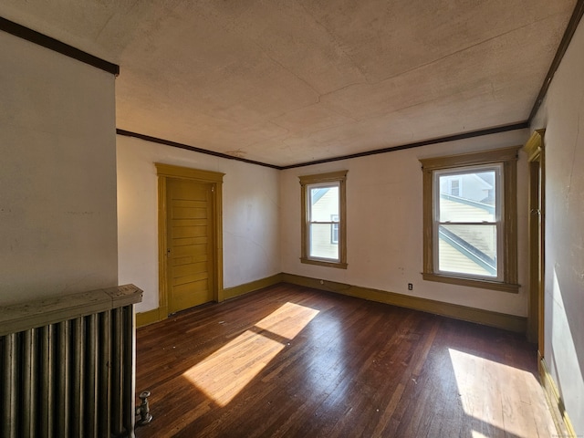 empty room featuring dark hardwood / wood-style floors and ornamental molding