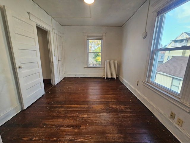 empty room featuring radiator and dark wood-type flooring