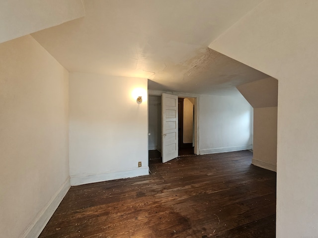 additional living space featuring dark hardwood / wood-style floors and vaulted ceiling