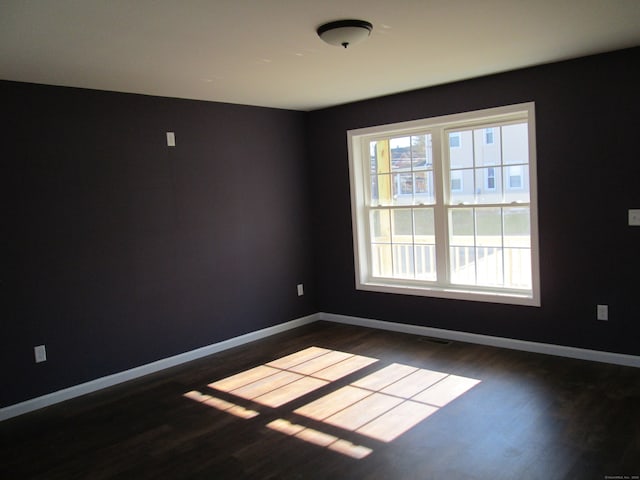 spare room featuring dark wood-type flooring