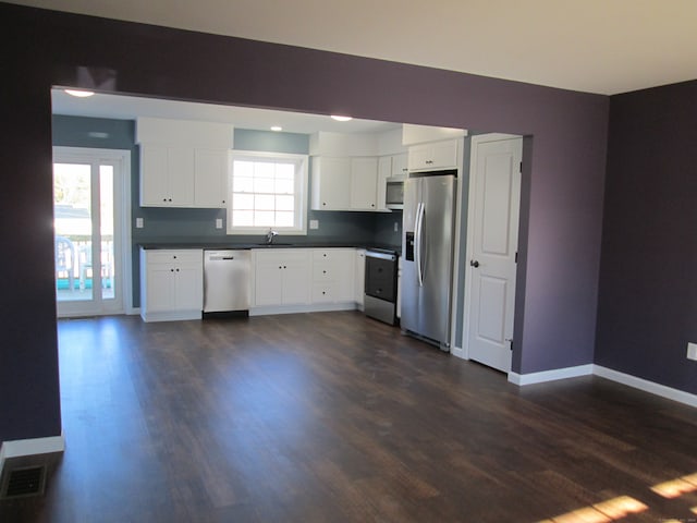 kitchen featuring dark hardwood / wood-style floors, sink, white cabinetry, and stainless steel appliances