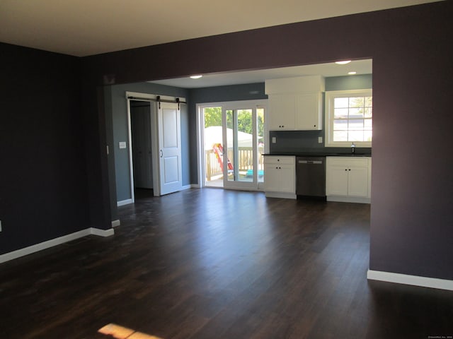 interior space with a barn door, dark hardwood / wood-style flooring, and sink