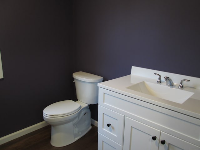 bathroom with vanity, hardwood / wood-style flooring, and toilet