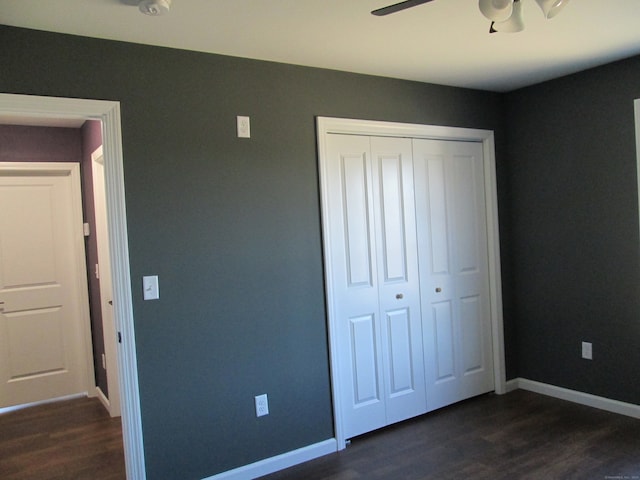 unfurnished bedroom with a closet, ceiling fan, and dark hardwood / wood-style flooring