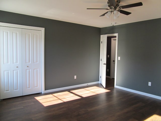 unfurnished bedroom with ceiling fan, dark hardwood / wood-style floors, and a closet