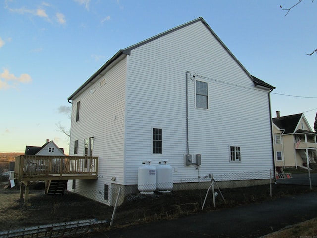 back house at dusk featuring a wooden deck