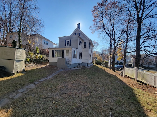 rear view of house featuring a lawn