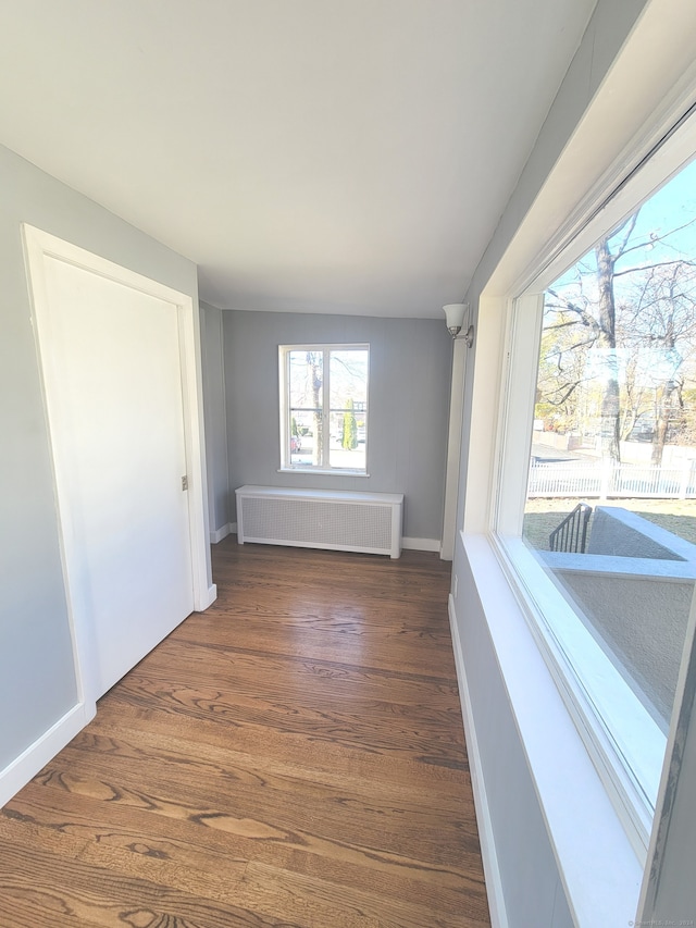 hallway featuring dark hardwood / wood-style flooring and radiator heating unit