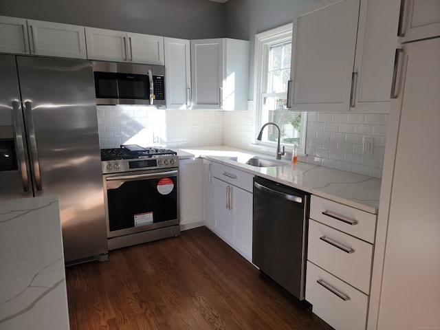 kitchen featuring dark wood-type flooring, white cabinets, sink, light stone countertops, and stainless steel appliances