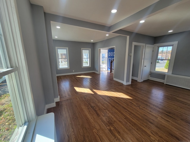 foyer with radiator heating unit, plenty of natural light, and dark wood-type flooring