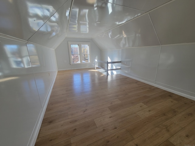 bonus room with vaulted ceiling and light hardwood / wood-style flooring