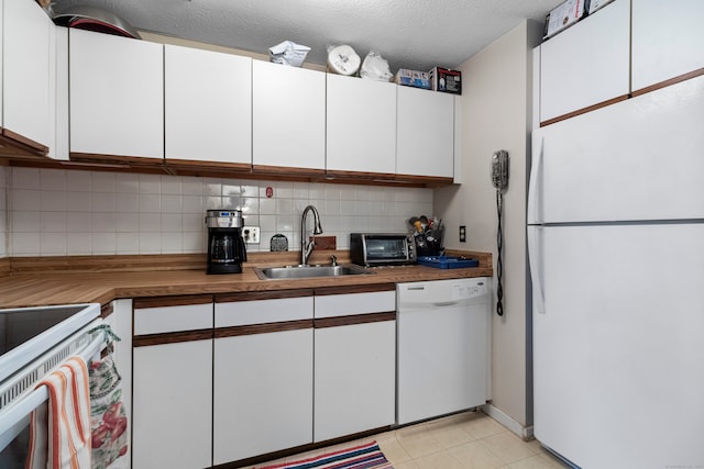 kitchen featuring white cabinets, backsplash, white appliances, and sink