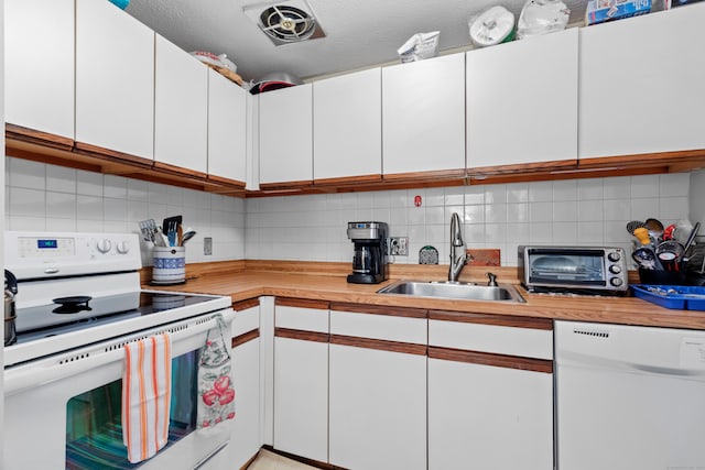 kitchen with sink, a textured ceiling, white appliances, decorative backsplash, and white cabinets