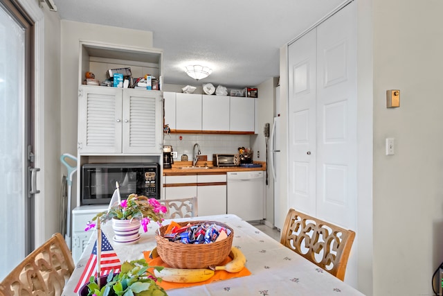 dining room featuring sink and a textured ceiling