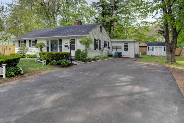 ranch-style house with a front lawn and a storage unit