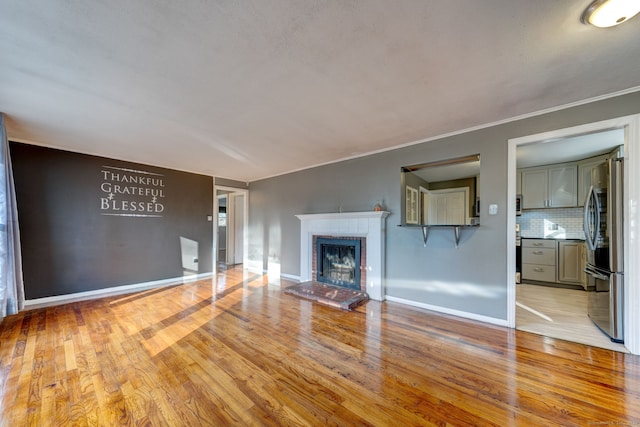 unfurnished living room with a fireplace and light hardwood / wood-style flooring