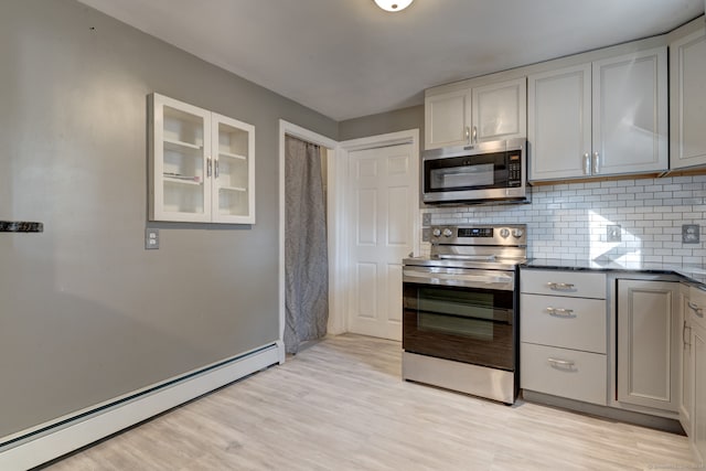 kitchen with light wood-type flooring, backsplash, stainless steel appliances, baseboard heating, and gray cabinets