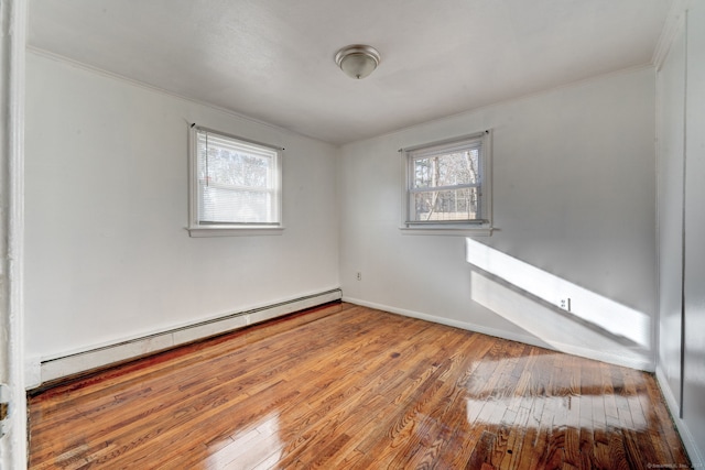 unfurnished room featuring hardwood / wood-style floors, a healthy amount of sunlight, and baseboard heating