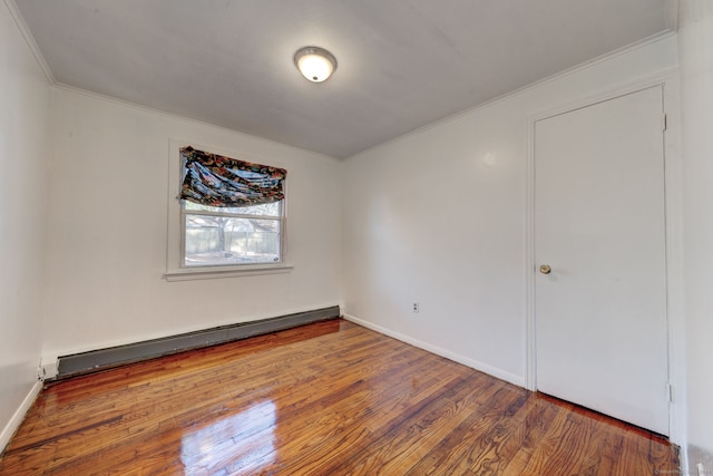 empty room with wood-type flooring and a baseboard radiator