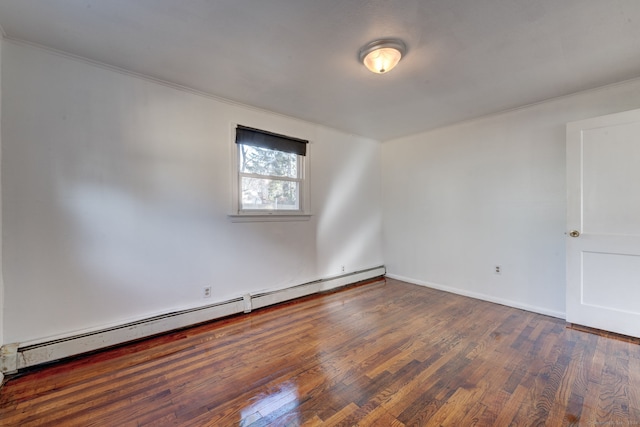 spare room featuring dark hardwood / wood-style flooring and a baseboard heating unit