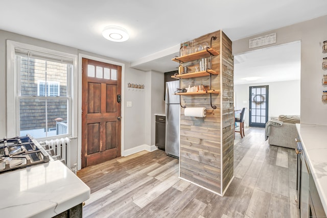 foyer entrance featuring light hardwood / wood-style flooring and radiator