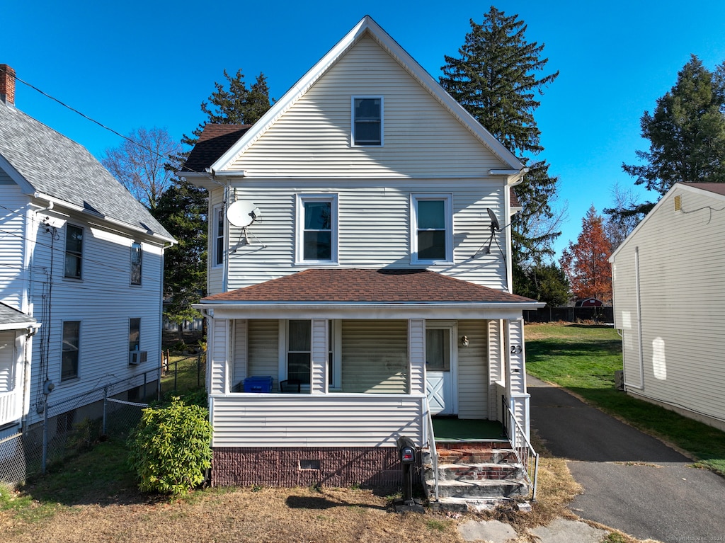 view of front property featuring covered porch and a front lawn