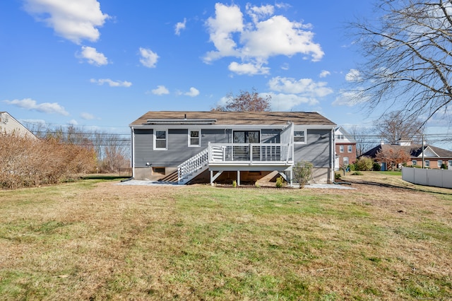 rear view of house featuring a deck and a lawn