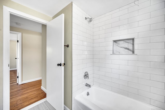 bathroom with hardwood / wood-style floors and tiled shower / bath