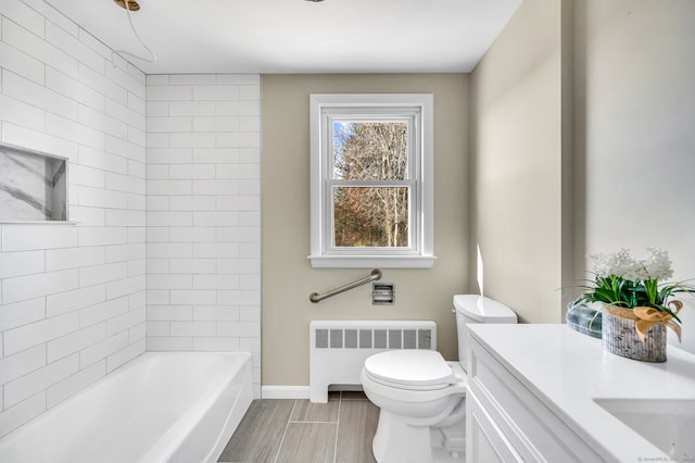 bathroom with vanity, toilet, and radiator