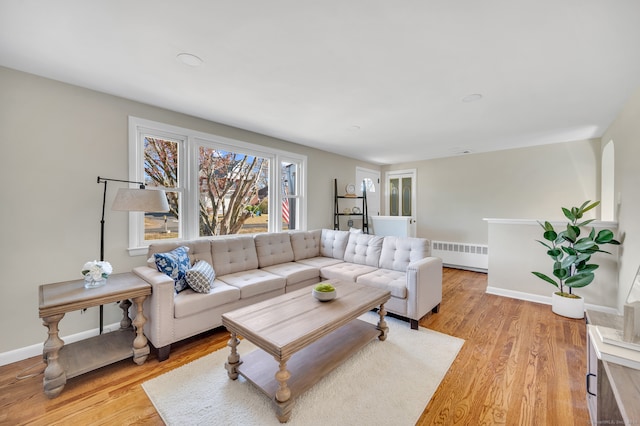 living room with radiator heating unit and light hardwood / wood-style flooring