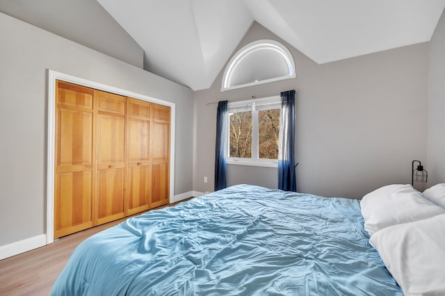 bedroom featuring a closet, wood-type flooring, and vaulted ceiling