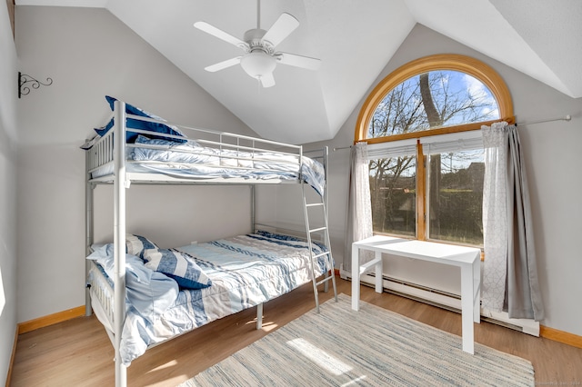 bedroom featuring a baseboard heating unit, hardwood / wood-style flooring, ceiling fan, and lofted ceiling